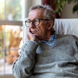 Sad senior man looking out the window