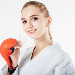 Woman in martial arts gi holding a sportsguard