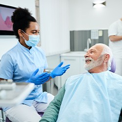Senior pent talking with dental team member