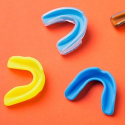 Sportsguards of different colors sitting on an orange surface