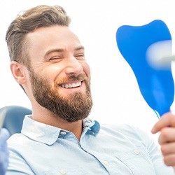 A handsome male patient admiring his treated smile