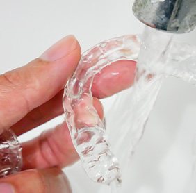 Invisalign patient in Williamstown rinsing trays