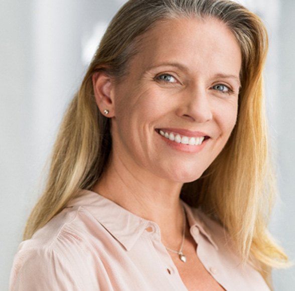 Senior woman with light pink shirt smiling