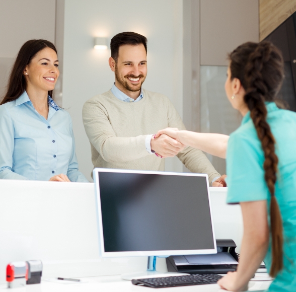 Dental team member at reception desk reviewing dental insurance