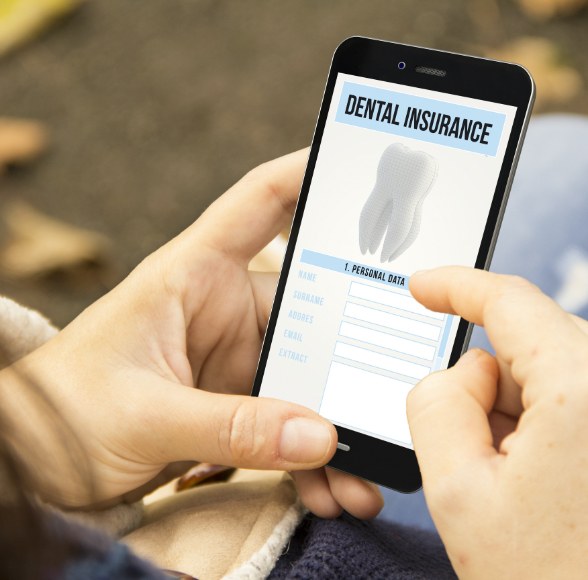 Patient looking at dental insurance forms on smart phone