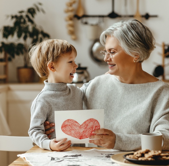 Older woman with dentures smiling at her grandchild