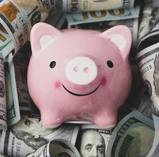 Piggy bank laying on $100 bills