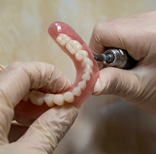 Dental technician polishing a denture