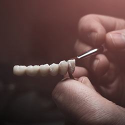 Dental technician painting artificial teeth