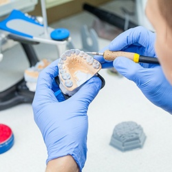 Dental technician carving denture mold