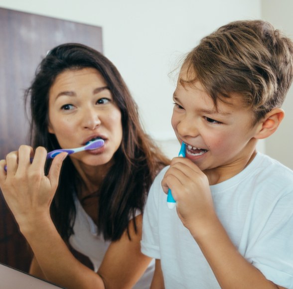 Mother and child brushing teeth to prevent dental emergencies