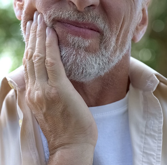 Close-up of a bearded man with tooth pain