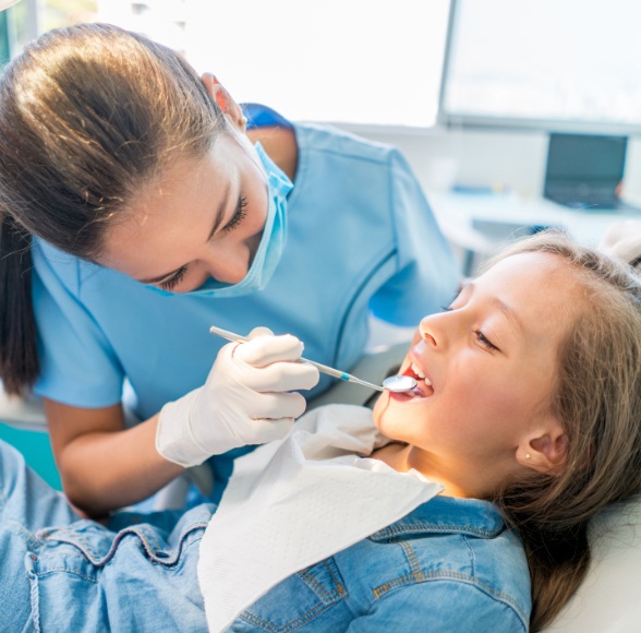 Dental team member examining young dental patient