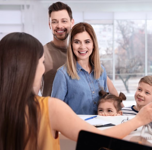 Family of four discussing affordable dental care and in house savings plans