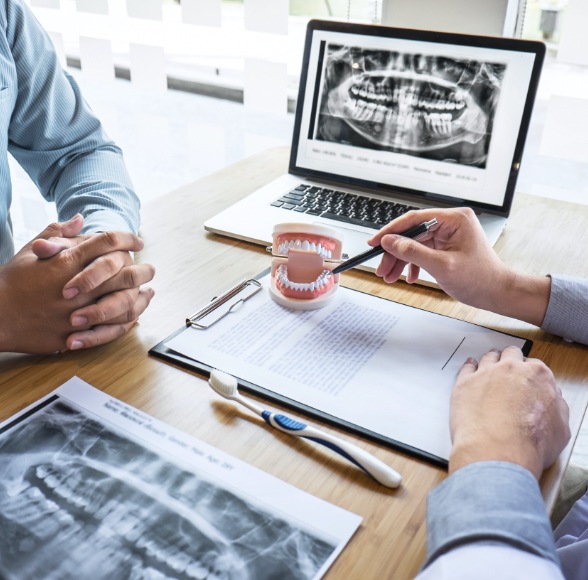 Dentist and patient discussing the process of getting dental implant dentures