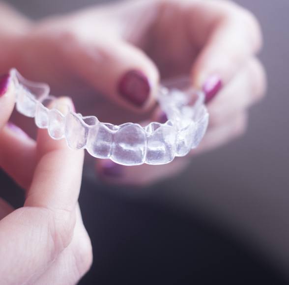 Hand holding an Invisalign tray