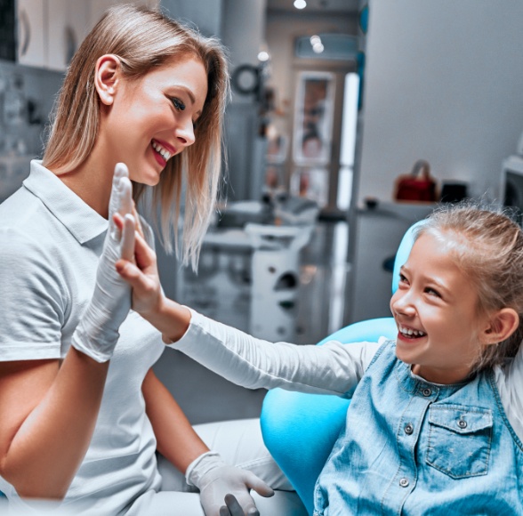 Child giving dental team member a high five