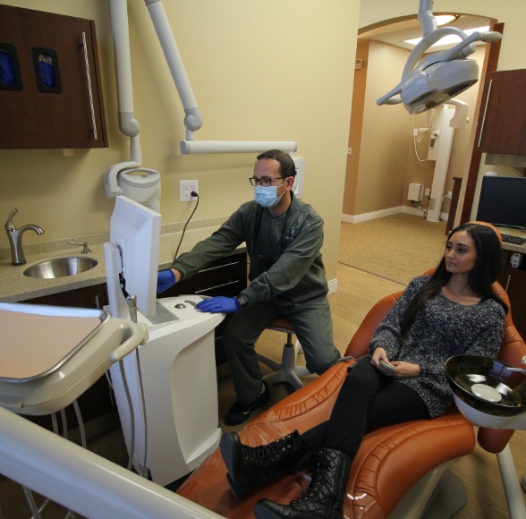 Dentist and patient in dental office for preventive dentistry checkup and teeth cleaning visit