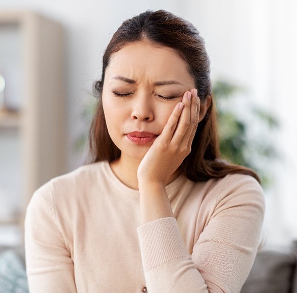 Closeup of woman struggling with tooth pain at home