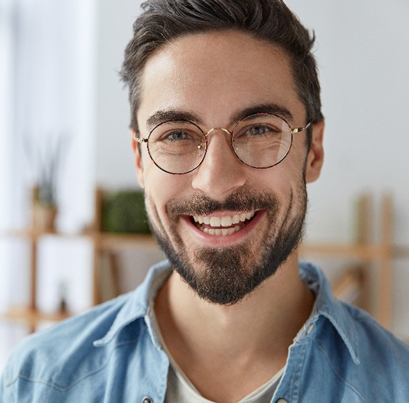 Closeup of man with glasses smiling at home