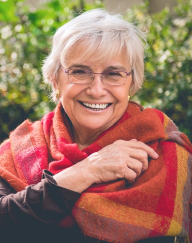 Woman with complete smile after replacing missing teeth