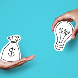 One hand holding a money bag graphic while another holds a lightbulb graphic