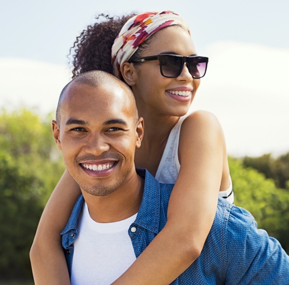 Man and woman with bright smiles after teeth whitening