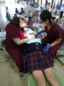 dental team cleaning a girl's teeth