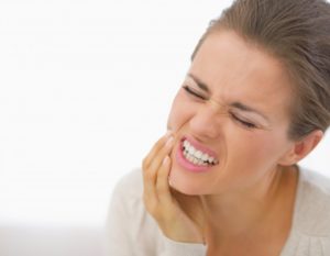 woman holding jaw from toothache pain