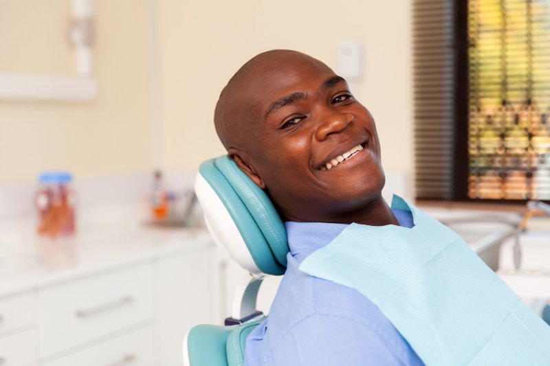 A young man sitting back in the dentist’s chair in preparation for his six-month checkup and cleaning