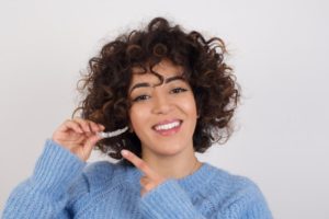 young woman holding Invisalign aligner