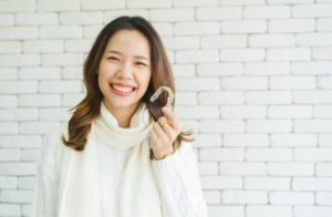 a woman smiling with her Invisalign treatment during the holidays