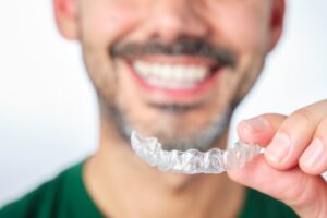 Man putting his Invisalign on just his top teeth