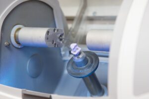 Dental crown being carved in milling machine